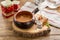 Vegetable soup in clay pot served with vodka pouring in shot glass on wooden table