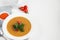 Vegetable soup with lentils on a white background. Served with chopped cherry tomatoes and herbs. Nearby are pieces of ciabatta.