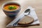 Vegetable soup in a pottery bowl, bread and spoon