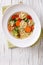 Vegetable soup with tortellini close-up. vertical top view