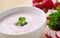 Vegetable spring radish soup. Bowl of radish soup surrounded by ingredients. Wooden background.
