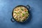 Vegetable stir fried rice, overhead shot on a blue background. Basmati with broccoli, green peas and carrots