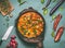 Vegetables chicken pan with curry sauce on kitchen table background with ingredients, top view, flat lay