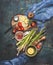 Vegetables cooking ingredients: green asparagus,tomatoes, lemon and flavoring on dark rustic background
