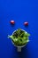 Vegetables in cup on blue background, minimalist photography