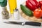 Vegetables on cutting board, bottle of vegetable oil, salt, condiment