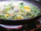 Vegetables fried in a pan close-up. Steam is coming. Defocus. vegetarian barely. Eco food