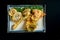 Vegetables fried in tempura, served in a white plate. Deep-fried asparagus, broccoli and mushrooms. Isolated over black background