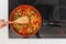 Vegetables are in a frying pan. Woman cooking colourful fresh vegetables on an electric stove.