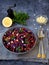 Vegetables salad with purple cabbage, carrot, sprouted mung, parsley on grey clay plate on dark background. Cole Slaw Salad of red