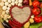 Vegetables in the shape of a heart on wooden background, vegetarian food.