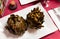 Vegetarian appetizer of baked artichokes served on white plate.