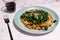 Vegetarian black beans risotto with charred kale and vegan cheese topping