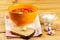 Vegetarian borsch in an orange bowl, sour cream, garlic, rustic bread on a wooden background. Vegetarian food. Healthy lifestyle