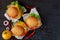 Vegetarian burgers with falafel, salad, cheese decorated with chili peppers, onion rings and yellow tomato on the black background