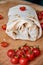 Vegetarian burrito with vegetables decorated with cardamom seeds on brown wooden background. On blurred foreground cherry tomatoes
