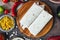 Vegetarian burrito on wooden board over black table surrounded by ingredients.