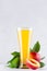 Vegetarian dieting drink - ripe fresh nectarines, green leaves and juice in elegant glass on white modern kitchen wood table, vert