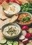 Vegetarian dips hummus, babaganush, muhammara over wooden background