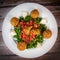 Vegetarian dish, falafel balls from spiced chickpeas with chopped parsley, fresh onions and tomato, tahini sauce
