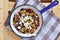 Vegetarian food with red beans,corn, mushroom, goat cheese, basil and onion on pan on wooden background