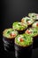 Vegetarian futomaki sushi roll with cucumber, salmon, pepper, avocado salad on a black mirror background