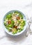 Vegetarian healthy lunch - pasta salad with fresh vegetables and feta on a light background, top view