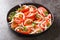 Vegetarian healthy tomato salad with onion and cilantro seasoned with olive oil close-up in a plate. Horizontal