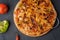 Vegetarian hot chili pizza on wholegrain flour dough on a wooden Board near the ingredients, top view