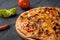 Vegetarian hot chili pizza on a wooden Board among vegetables and hot peppers, close-up