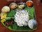 vegetarian kerala indian food on banana leaf in lunch and dinner with rice curd sambar chips