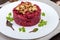 Vegetarian Lenten dish: a salad of beets with walnuts and garlic in a white plate