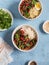 Vegetarian lunch table in the asian style - bowls with rice, noodles, vegetable stir fry. On a blue background