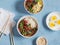 Vegetarian lunch table - rice, noodles, vegetable stir fry, boiled eggs. On a blue background