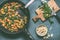 Vegetarian meal with Potato gnocchi , spinach and vegetables sauce in frying pan on rustic table