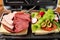 Vegetarian and meat-eating sandwich. Comparison. Sandwich stuffed with meat sausages and ham against a stuffing of lettuce, onion