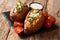 Vegetarian menu baked sweet potato with lentils served with sour cream and tomatoes close-up on a slate board. horizontal