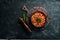 Vegetarian menu. Stewed beans in tomato sauce with parsley and chili. In a black bowl. Top view.