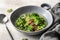 Vegetarian minestrone soup with green vegetables and lentils in gray plate on textured background