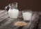 Vegetarian pine nut milk in a glass cup and jug on wooden background. Horizontally