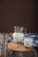 Vegetarian pine nut milk in a glass cup and jug, on a wooden stand with a blue linen napkin