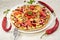 Vegetarian pizza with tomatoes, bell pepper, onion rings, green olives, cheese and spices on white background close up