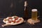 Vegetarian pizza with vegetables on roman dough, pinsa. on a dark wooden background. Homemade beer. Direct view