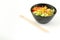 Vegetarian poke bowl in design black bowl with chopsticks below, isolated on white background. Green cucumber, red pepper, peanuts