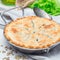 Vegetarian pot pie with lentil, mushroom, potato, carrot and green peas, covered with puff pastry, in baking dish, square