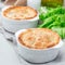 Vegetarian pot pie with lentil, mushroom, potato, carrot and green peas, covered with puff pastry, in baking dish, square