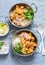 Vegetarian potato and cauliflower curry with rice in curry dishes on a blue background, top view. Vegetarian healthy food concept