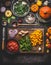 Vegetarian pumpkin dish cooking preparation. Various healthy organic vegetables on cutting board with knife on rustic kitchen tabl