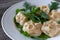 Vegetarian pumpkin mantas on a white plate, decorated with dill and parsley