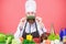Vegetarian recipe concept. Choose vegetarian lifestyle. Man cook hat apron hold fresh vegetables. Vegetarian restaurant